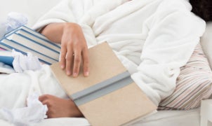 A Person Lying in Bed Reviewing Books
