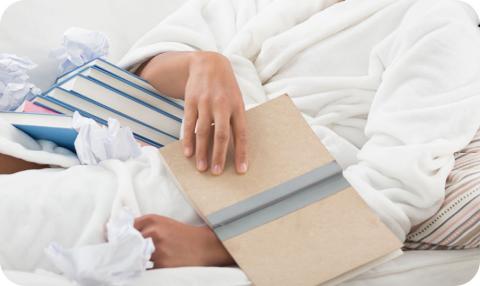 A Person Lying in Bed Reviewing Books